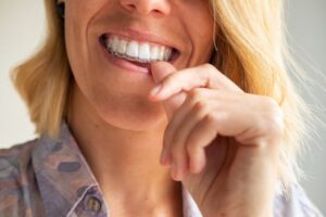 Woman inserting her Invisalign aligners