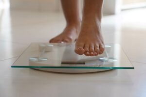 Person stepping on glass bathroom scale